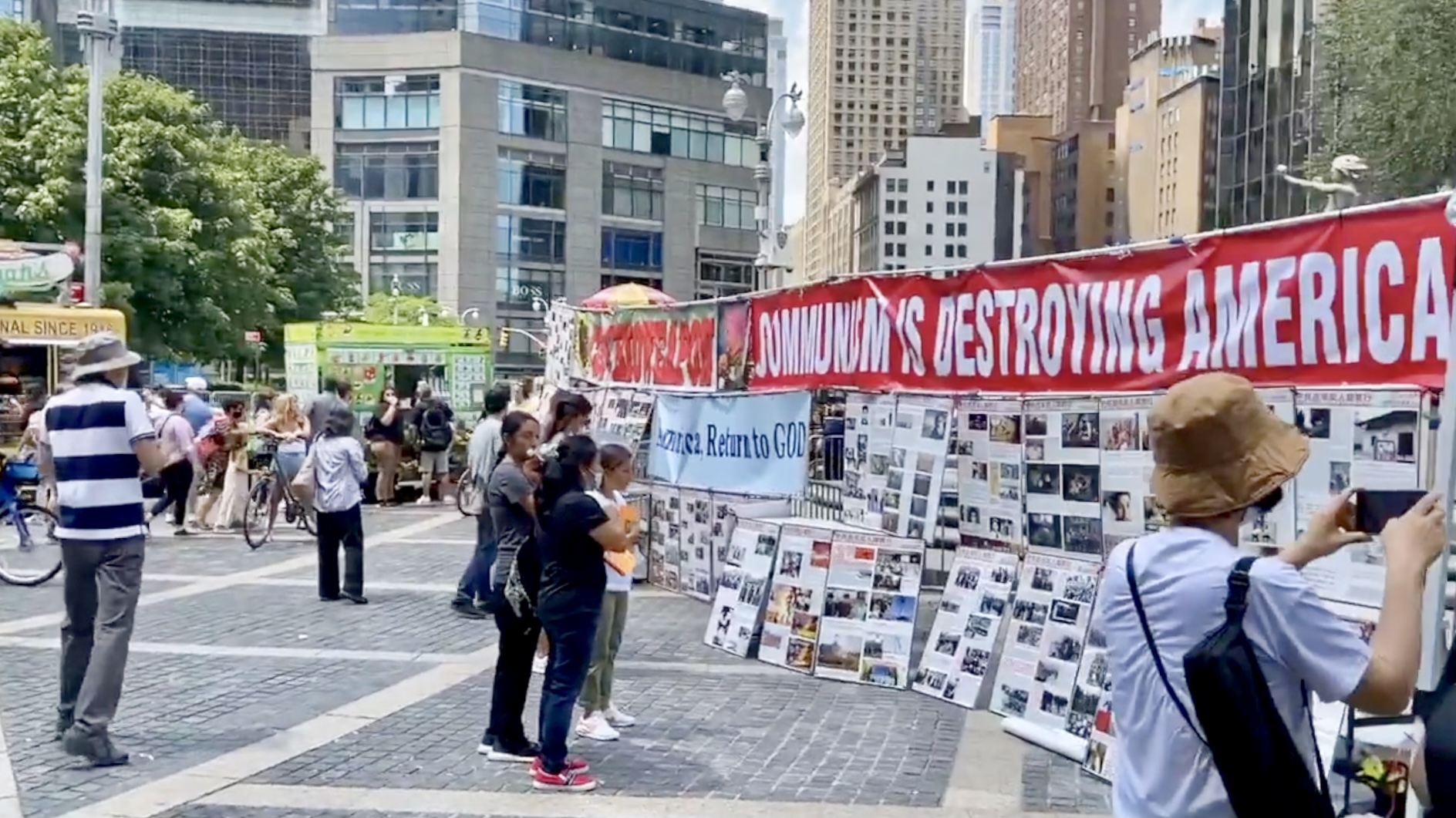 2022年7月24日，揭露中共百年反人類罪行圖片展在紐約市曼哈頓的中央公園西南角展出，吸引大批市民觀看。（白節敏提供）