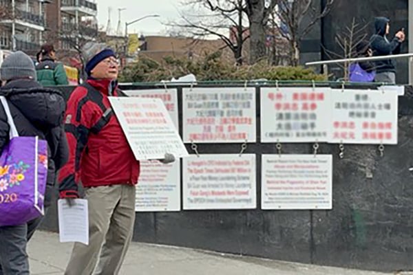 2025年2月2日,紐約法拉盛亞美國際旅遊公司(Asia America International Travel)的老闆朱立創在法拉盛展示攻擊法輪功的標語,並散發《紐約時報》對神韻的不實報道。(大紀元)