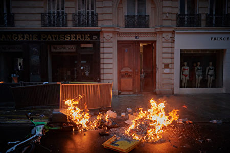 2023年4月14日，法國巴黎，反對馬克龍年金改革的示威活動中，抗議者在街上點燃了垃圾。 （Kiran Ridley/Getty Images）