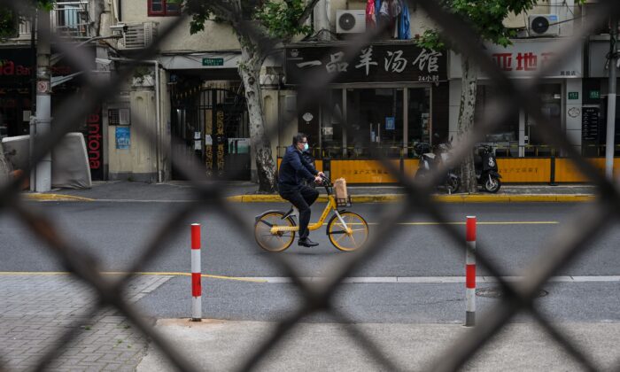 2022年5月19日，上海靜安區被封鎖期間街道上騎單車的居民。（Hector Retamal/AFP via Getty Images）