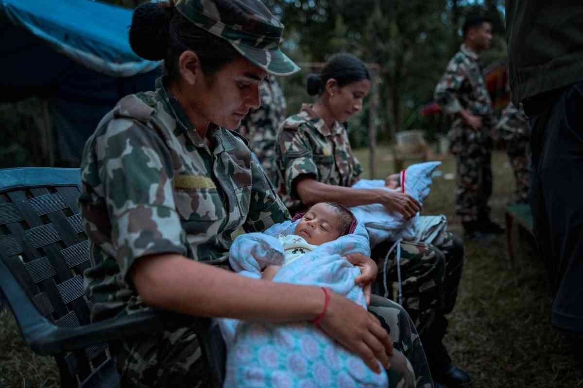2026年8月27日，在尼泊爾努瓦科特縣（Nuwakot）特里蘇里巴扎爾（Trishuli Bazar）的一處陸軍救援營，士兵照護從偏遠城鎮救出的嬰兒。（Ezra Acayan/Getty Images）