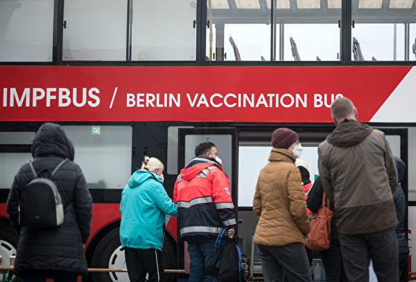 2021年11月17日，德國柏林，民眾在一輛巴士前排隊等候接種COVID-19（新冠病毒）疫苗。（Stefanie Loos/AFP via Getty Images）