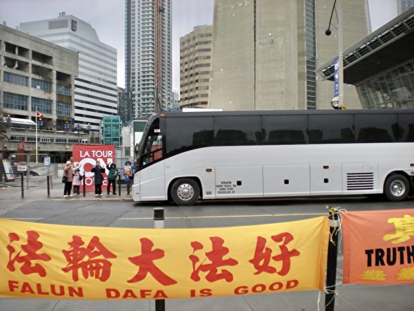 法輪功學員等待中國遊客的到來，在馬路對面掛起「法輪大法好」等橫幅。（大紀元）