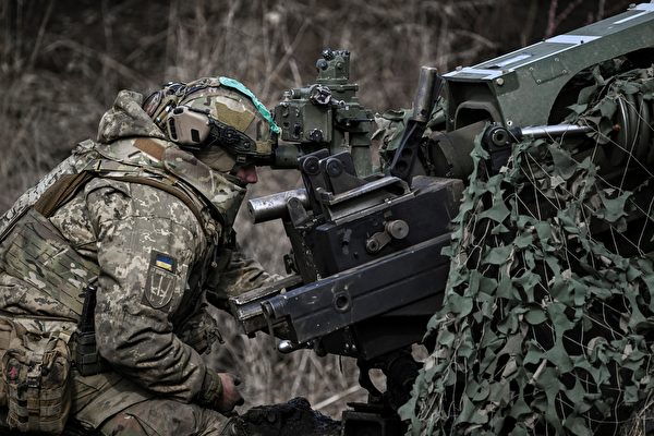 2023年3月8日，巴赫穆特（Bakhmut）附近，在俄烏戰爭期間，一名烏克蘭士兵使用105毫米榴彈炮瞄準俄軍陣地。（Aris Messinis/AFP）