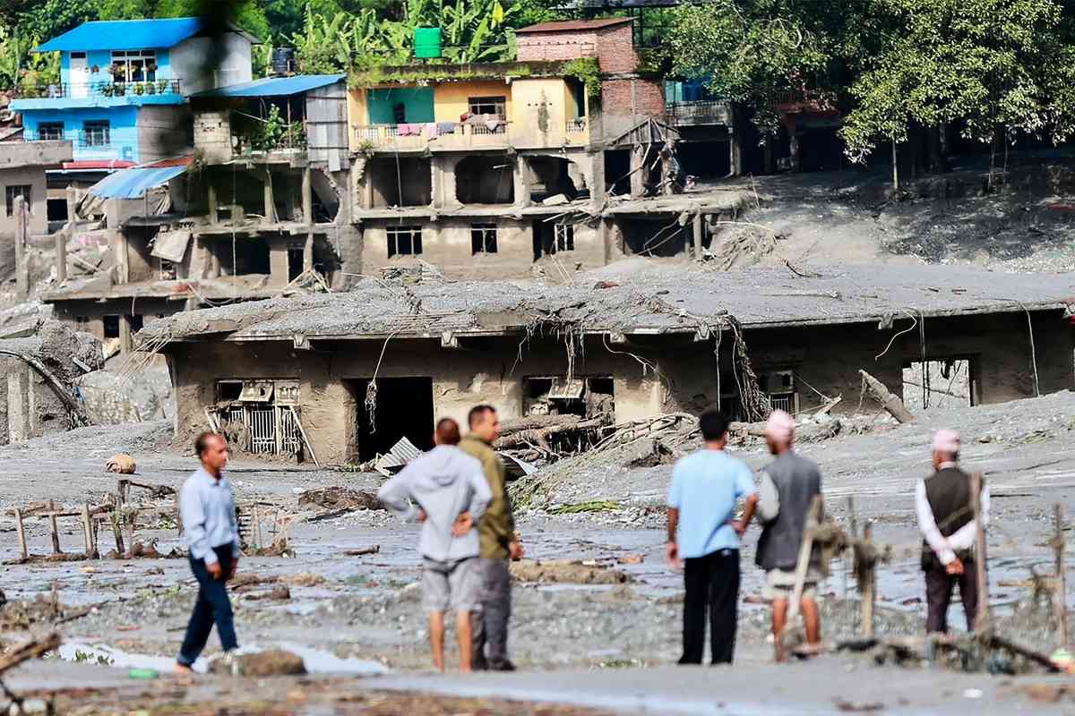2026年8月27日，尼泊爾努瓦科特縣（Nuwakot）德夫加特（Devghat）的許多房屋被淤泥掩埋，當地民眾聚在一旁觀看。（Prabin Ranabhat/AFP via Getty Images）