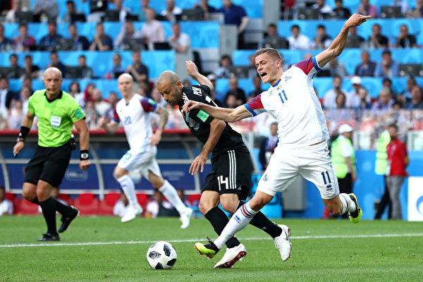 2018年6月16日，世界盃D組首輪比賽，冰島球員（白色球衣者）利用身材優勢多次用身體碰撞犯規來延緩阿根廷球員的進攻。（Ryan Pierse/Getty Images）