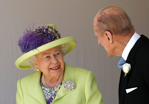 這張攝於2018年5月19日的照片顯示，英國女王伊利沙伯二世（Elizabeth II，左）在跟英國菲利普·愛丁堡公爵（Prince Philip, Duke of Edinburgh，右）說悄悄話。此前，他們剛剛在溫莎堡參加了英國王子哈里、薩塞克斯公爵（Prince Harry, Duke of Sussex）和美國女演員梅根·馬克爾（Meghan Markle）的結婚典禮。（ALASTAIR GRANT/POOL/AFP via Getty Images）
