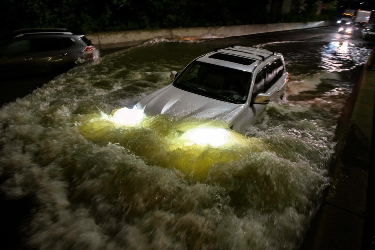 2021年9月2日清晨，一名駕車人駕車穿過紐約布魯克林一條被洪水淹沒的高速公路。風暴艾達（Storm Ida）的殘餘力量給該地區帶來破紀錄的降雨和暴洪。（ED JONES/AFP via Getty Images）