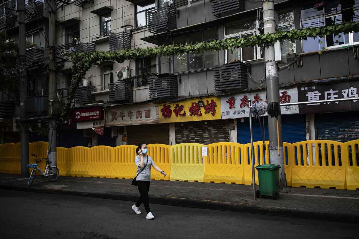 2021年8月11日，中國湖北省武漢市，COVID-19疫情蔓延，當局在商店前設置路障阻擋民眾進入，街上一位市民戴著口罩。（Getty Images）