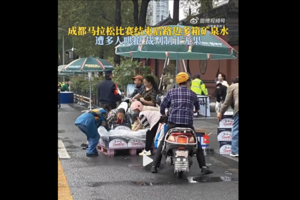 成都馬拉松比賽後,發生物資被明搶事件——沿途多個補給站剩餘的大量整箱的礦泉水等物資被市民哄搶,工作人員勸阻無效。(影片截圖)