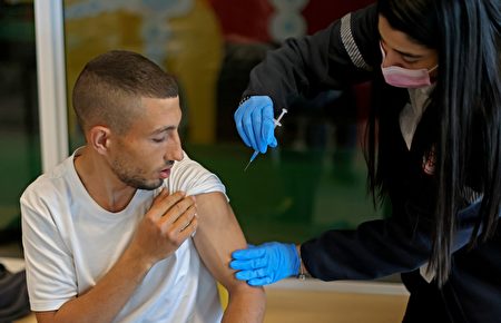 2021年2月22日，以色列紅大衛盾會醫療機構的一名醫護人員，在為一名男子注射輝瑞疫苗。（AHMAD GHARABLI/AFP via Getty Images）