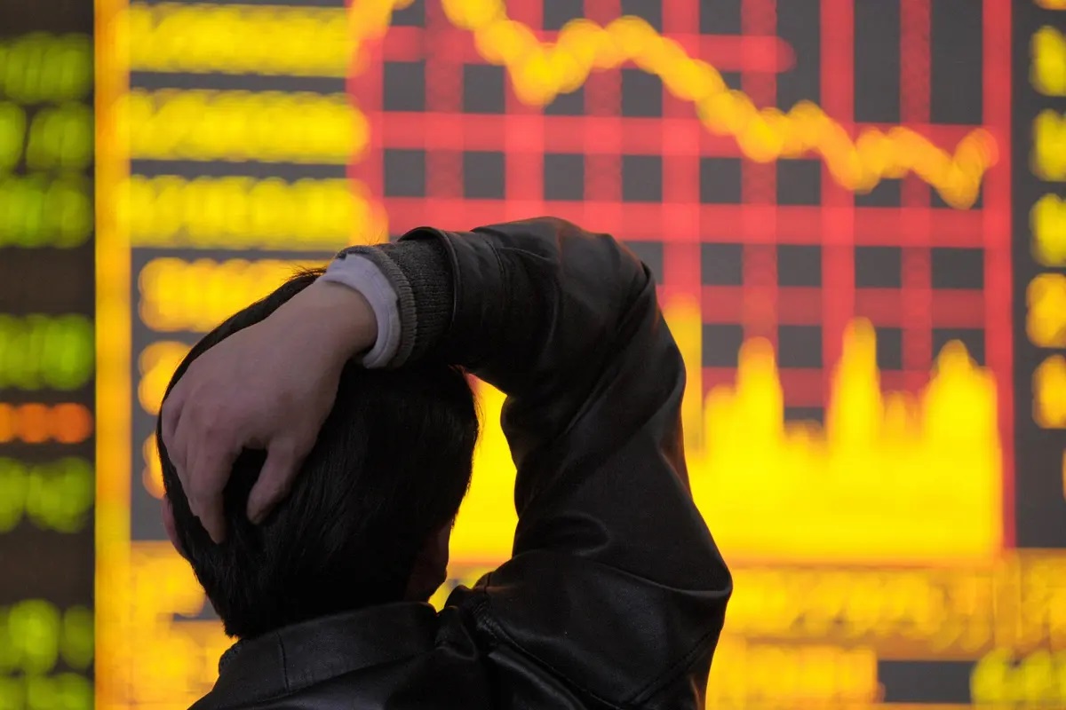 2008年3月18日，中國西南部四川省成都市的一家證券公司，一名男子正在觀看顯示股價指數下行圖的電子板。（Liu Jin/AFP via Getty Images）