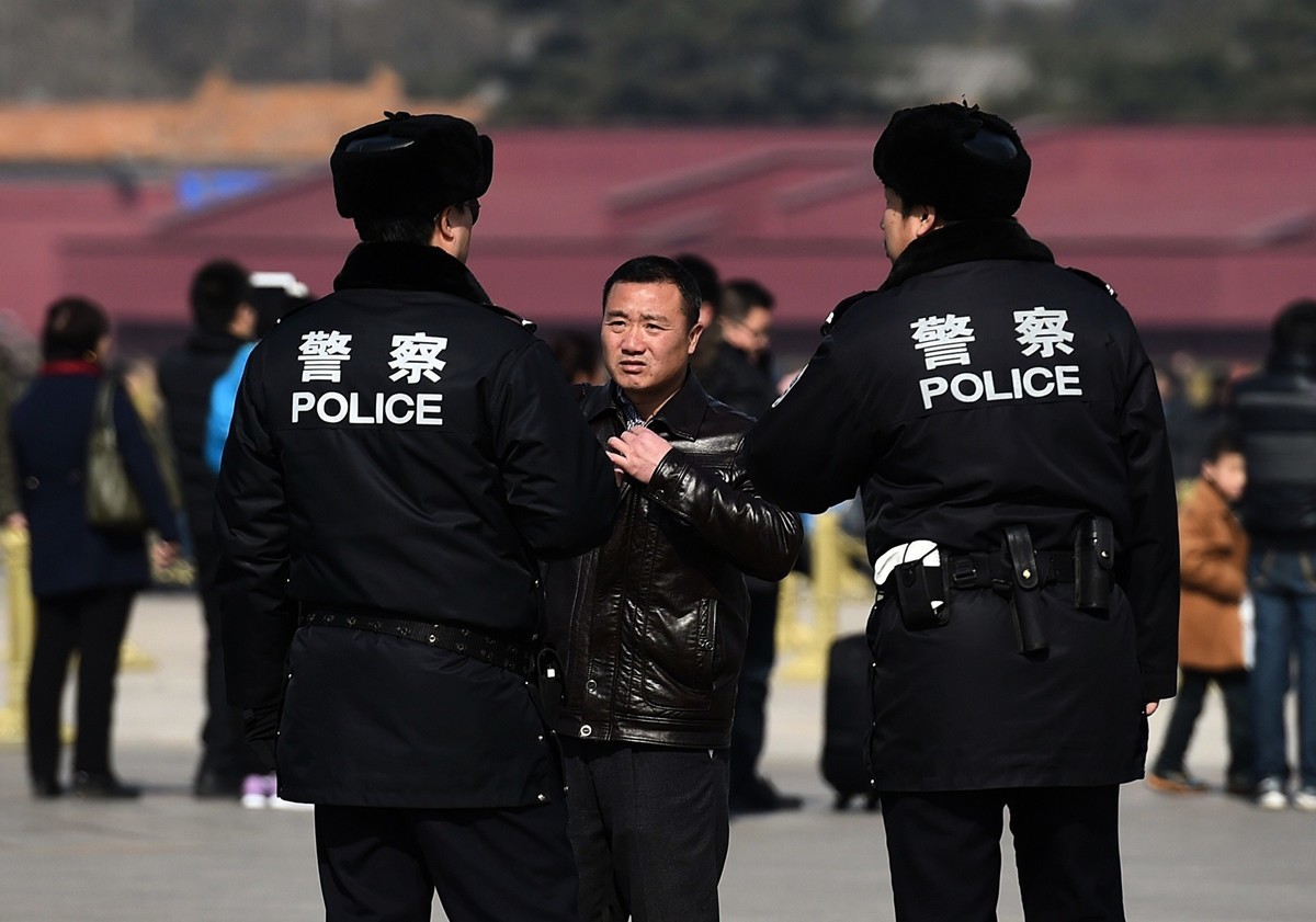 2015年3月2日，北京天安門廣場附近的一名男子在接受警方檢查。（GREG BAKER/AFP/Getty Images）