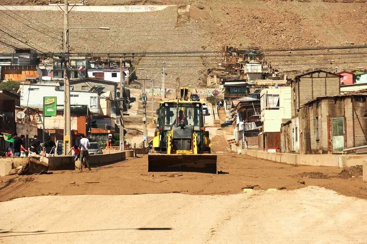 2026年8月19日，智利安托法加斯塔大區（Antofagasta）沿海城市托科皮亞（Tocopilla）因極端暴雨引發嚴重的泥石流災情，一輛輪式推土機在清除街道上的淤泥和碎石。（Jorge Perez/AFP via Getty Images）