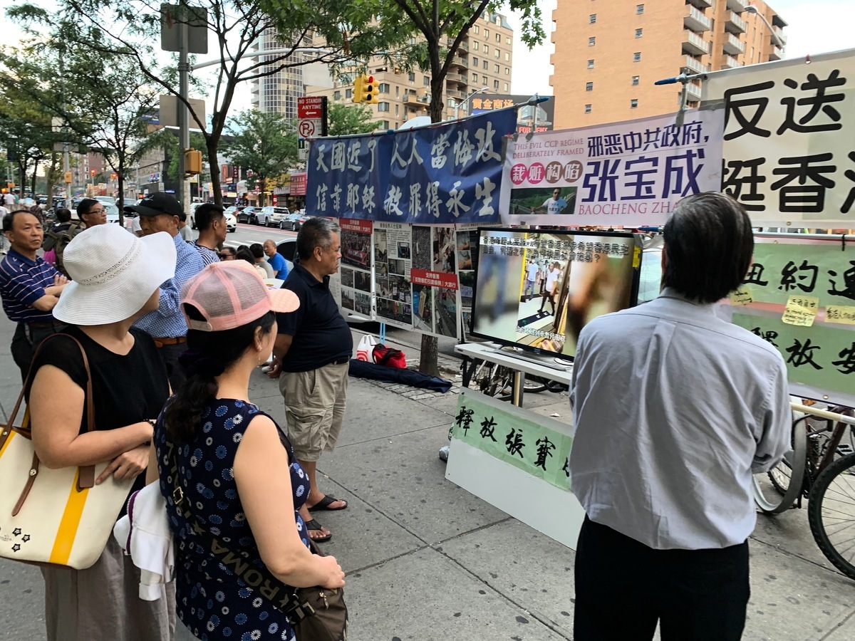 部份華人在法拉盛圖書館前築起「連儂牆」，聲援港人反抗中共暴政，吸引路人駐足觀看。 （林丹/大紀元）