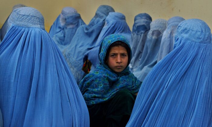 圖為2003年2月23日，在阿富汗婦女排隊等候在喀拉坎健康診所接受治療。（Paula Bronstein/Getty Images）