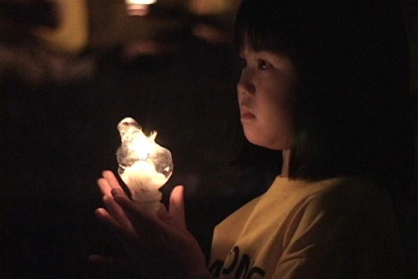 資料照。圖為一位兒童在燭光悼念被中共迫害致死的法輪功學員。（明慧網）