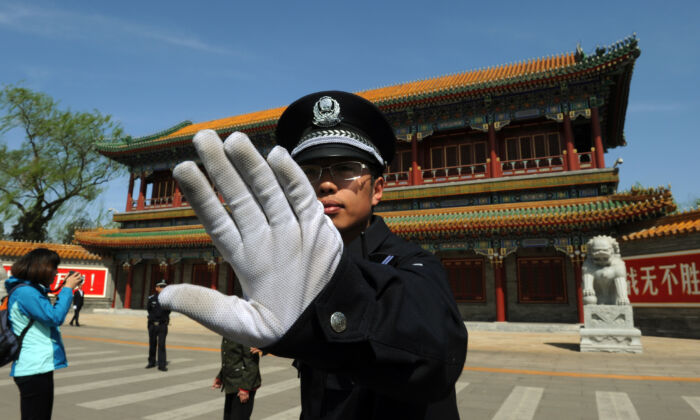2012年4月11日，在中南海外，一名警察阻止人們拍照。（Mark Ralston/AFP/Getty Images）