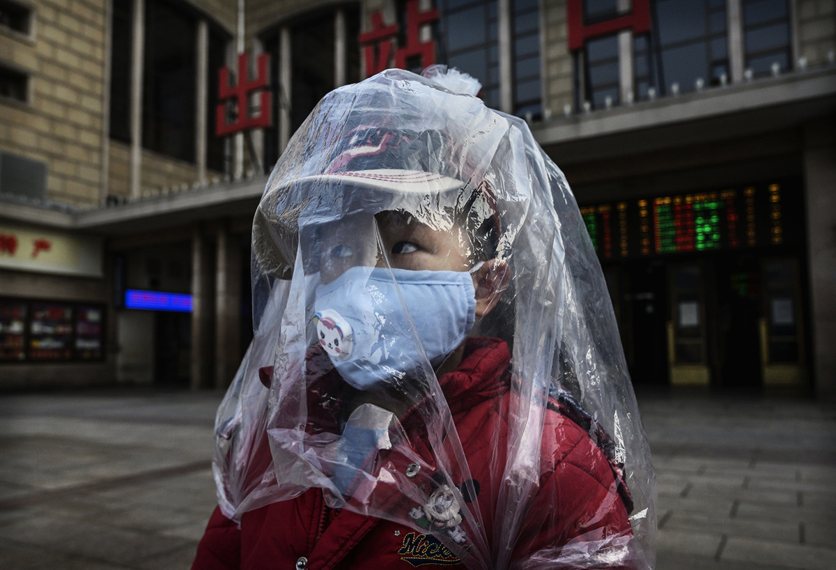 在中共肺炎疫情衝擊下，有些大陸民眾穿上奇特的防護服保護自己。圖為2020年2月12日，大陸一名穿著塑膠袋作為防護服的男孩出現在北京。（Kevin Frayer/Getty Images）