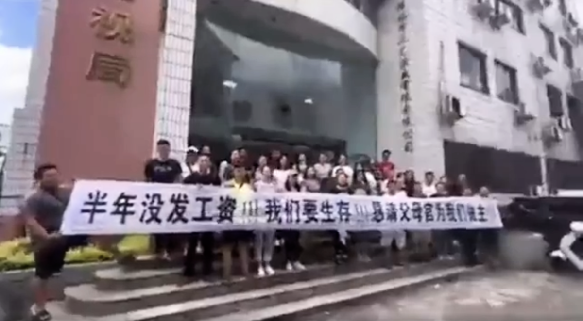 2023年9月網傳影片顯示，廣西桂林市廣電局門口，大約三十多人在拉橫幅追薪。（影片截圖）