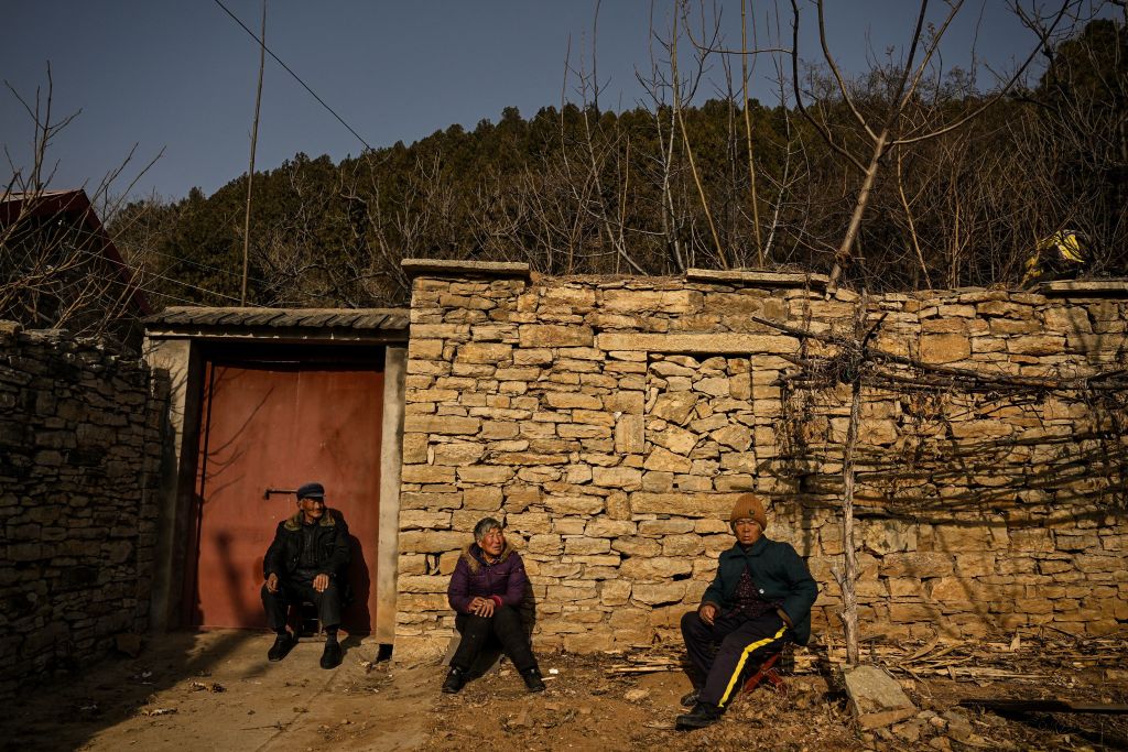 圖為2023年1月7日，山東泰安的鄉村地區，幾名老人坐在一個住所前。（Noel Celis/AFP via Getty Images）