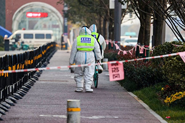 2021年12月22日，在中國陝西省西安市的一個封鎖區內，保安正在巡邏。西安市最近新冠疫情病例數飆升。（STR/AFP via Getty Images）