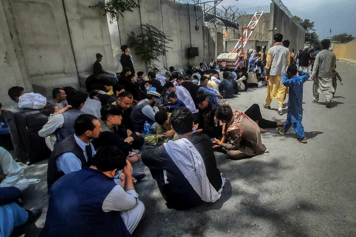 圖為2021年8月17日，阿富汗人坐在喀布爾的法國大使館外等待離開阿富汗。（ZAKERIA HASHIMI/AFP via Getty Images）