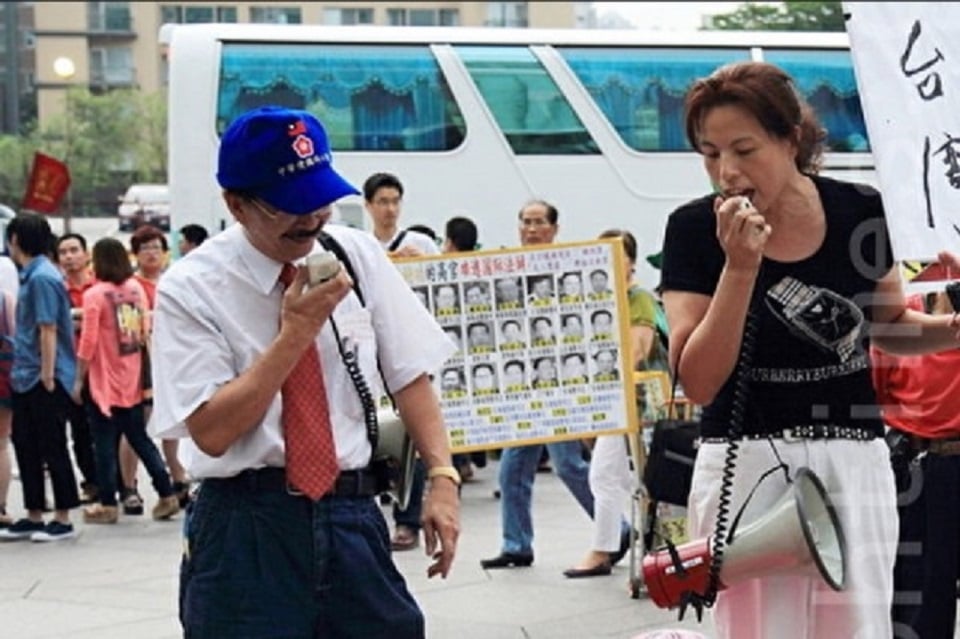 圖為台灣愛國同心會會長周慶峻（左）及秘書長張秀葉（右），2017年在台北101大樓前對法輪功學員施以恐嚇、妨害自由等手段。資料照。（Ke-Ren／大紀元）
