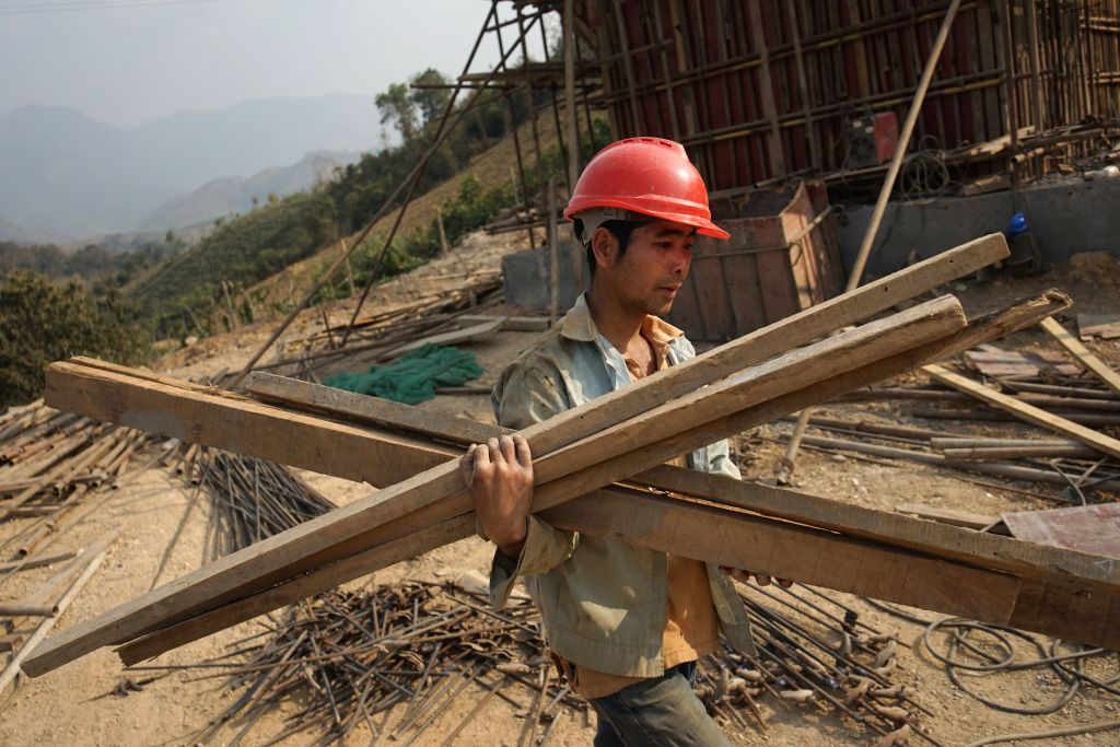 2020年2月8日，一名中國工人在老撾搬運建築材料。這是中共價值萬億美元的「一帶一路」倡議在當地的建設項目。（Aidan Jones/AFP via Getty Images）