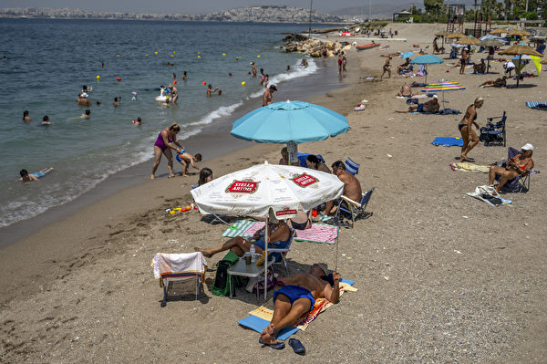 2023年7月15日，希臘和其它南歐國家一樣遭受熱浪襲擊，雅典附近的阿里莫斯海灘上遊客在消暑。（Angelos Tzortzinis/AFP via Getty Images）