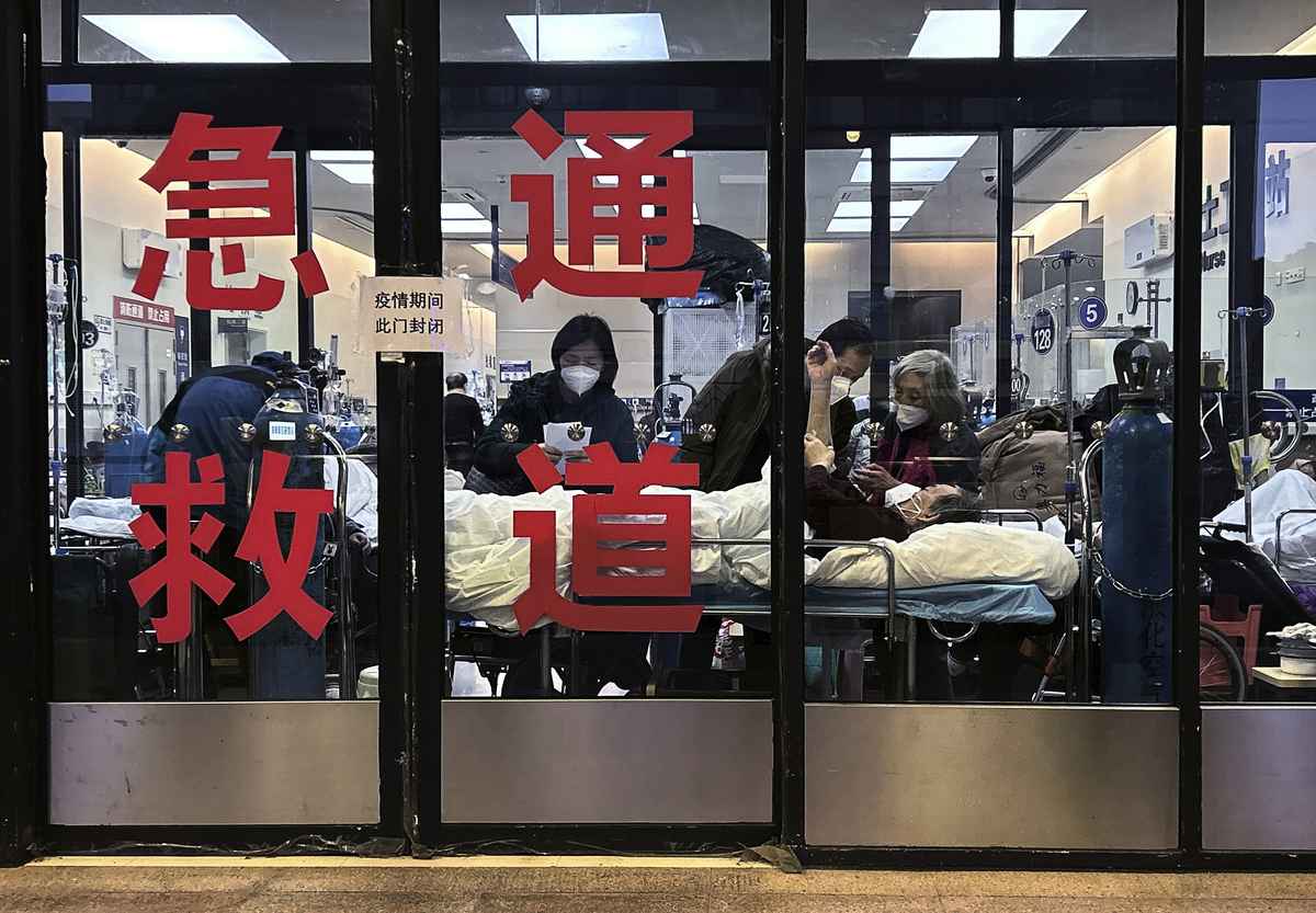 2023 年 1 月 14 日，在中國上海的一家醫院，急症室被用作溢出區的封閉入口通道中可以看到患者和護理人員。（Kevin Frayer/Getty Images）