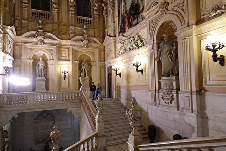 都靈王宮的樓梯由貝內代托‧阿爾菲里（Benedetto Alfieri）設計建造，作為通往國家元首的辦公室的通道。西班牙王室的雕塑傲然矗立在後殿中，在高聳的空間中註視著遊客。隨著層級的提升，黃色和淡粉色色調隨著發生微妙變化，給每一層的牆壁都創造了額外的維度。（Guilhem Vellut/CC BY 2.0）