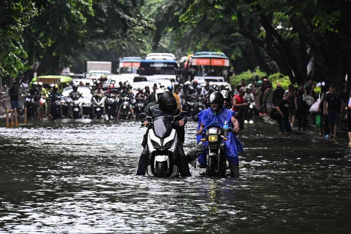 2026年8月17日，在菲律賓首都馬尼拉，多條街道因短時強降雨而嚴重積水，民眾被迫涉水而行。（Jam Sta Rosa/AFP via Getty Images）