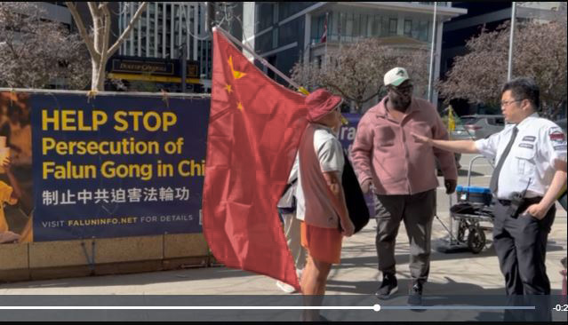 2025年10月2日下午,一位華人在中共駐多倫多領事館簽證處前(393 University Avenue, Toronto)騷擾法輪功學員。一位路人過來勸阻和制止他,一位大樓保安也試圖制止他。(潘學峰提供)