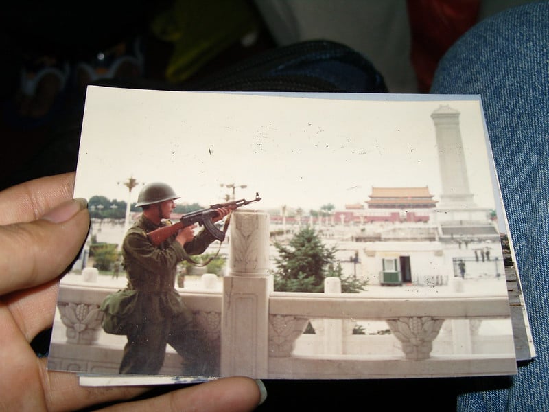 1989年6月5日,一名中共士兵在北京天安門廣場南端舉槍對著廣場上的紀念碑方向。公民記者周曙光於2007年6月17日翻拍,於2012年6月3日上傳flickr。(周曙光/ CC BY-NC-SA 2.0. )
