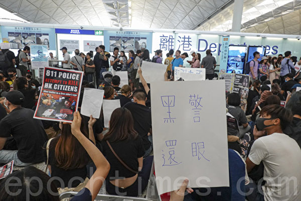 2019年8月12日，港人在香港機場展開「警察還眼」集會，民眾以「黑警還眼」、「811警察企圖謀殺香港市民」等各式中英文展板和標語表達抗議。（余鋼／大紀元）