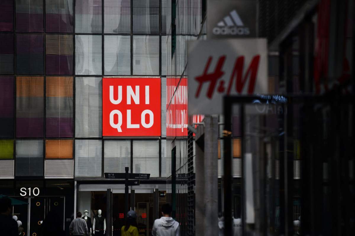瑞典時裝品牌H&M拒新疆棉事件持續發酵，還波及耐克、阿迪達斯等品牌。圖為2021年3月25日北京H&M及優衣庫商場畫面。（GREG BAKER/AFP via Getty Images）