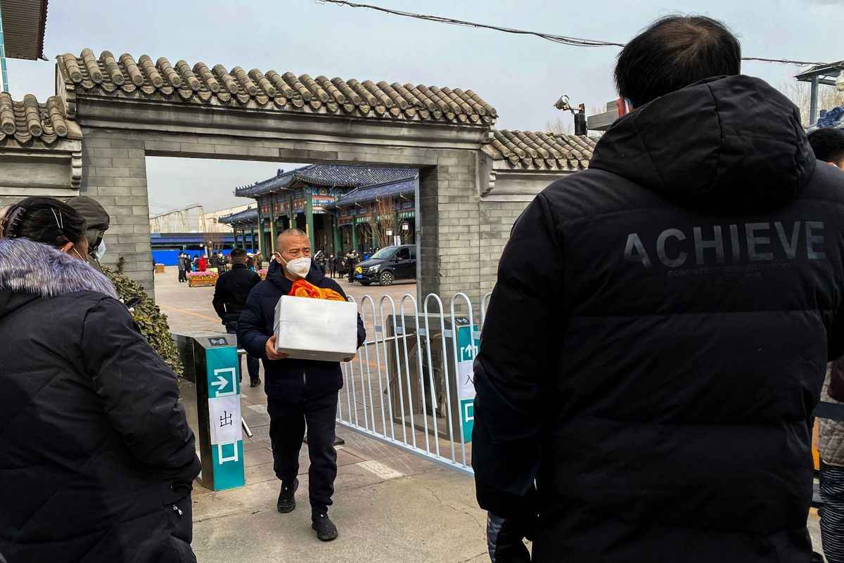  2022年12月20日，北京，一名男子抱著一骨灰盒走出火葬場。北京火葬場的工作人員在12月16日表示，因為面臨COVID病例激增，他們不堪重負。（Noel Celis/AFP via Getty Images）