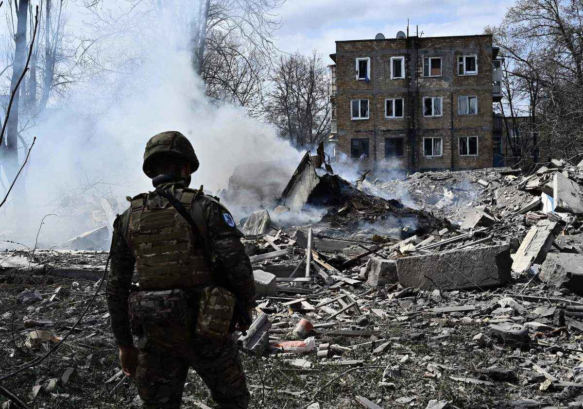 2023年4月10日，俄羅斯持續入侵烏克蘭之際，烏克蘭白衣天使特警隊（White Angels Special Police Team）一名成員站在頓涅茨克地區（Donetsk）前線城鎮阿夫迪夫卡（Avdiivka）一棟毀於空襲的居民樓前。（GENYA SAVILOV/AFP via Getty Images）