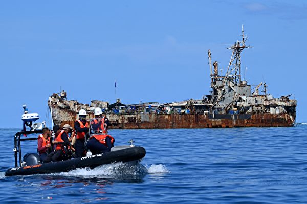 資料圖片:2023年11月10日,菲律賓海岸警衛隊人員和記者在拍攝完停靠在南海仁愛礁(Second Thomas Shoal)的「馬德雷山號」(BRP Sierra Madre)後,乘坐一艘硬質充氣艇(左)返回。由於主權之爭,菲律賓對駐紮在這艘登陸艦上的部隊補給工作長期面臨中共阻撓。(Jam Sta Rosa/AFP via Getty Images)