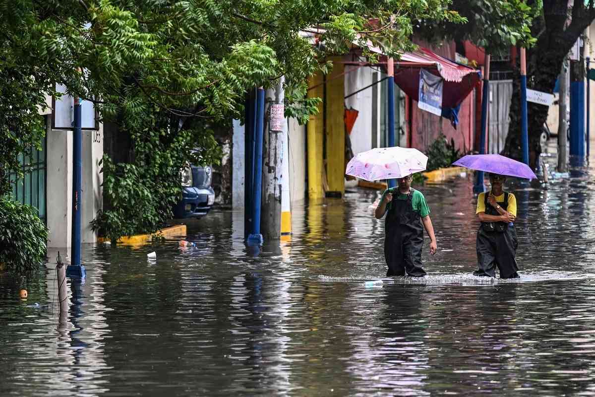 2026年8月17日，在菲律賓首都馬尼拉，多條街道因短時強降雨而嚴重積水，民眾被迫涉水而行。（Jam Sta Rosa/AFP via Getty Images）