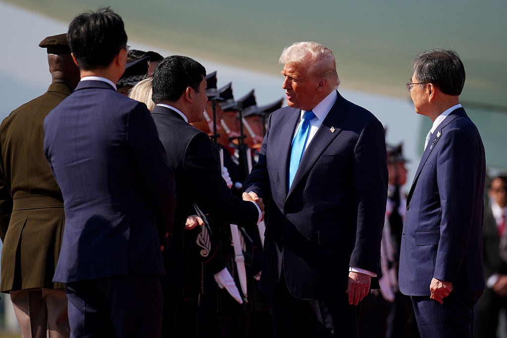 2025年10月29日:美國總統特朗普抵達韓國釜山金海國際機場,並與官員握手致意。 (Andrew Harnik/Getty Images)