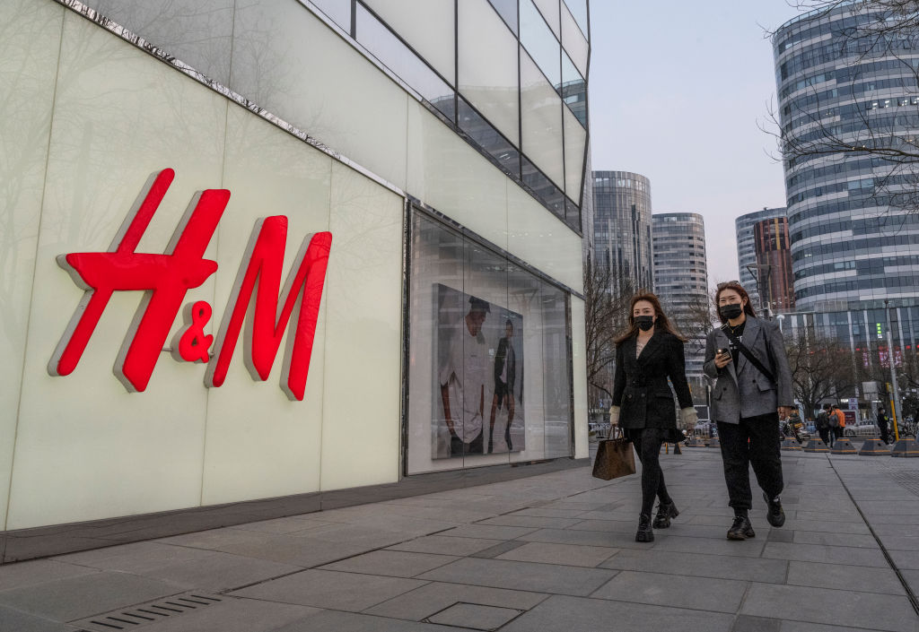H&M表態拒用新疆血棉，在中國大陸遭到部份城市的抵製出現升級現象。圖為2021年3月25日北京行人行經一家H&M門店。（GREG BAKER/AFP via Getty Images）