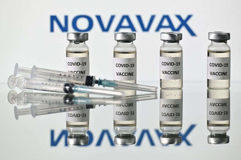 2020年11月17日，一張插圖圖片顯示了美國諾瓦瓦克斯公司的標誌，以及貼有COVID-19疫苗字樣的貼紙的小瓶和注射器。（Justin Tallis/AFP via Getty Images）