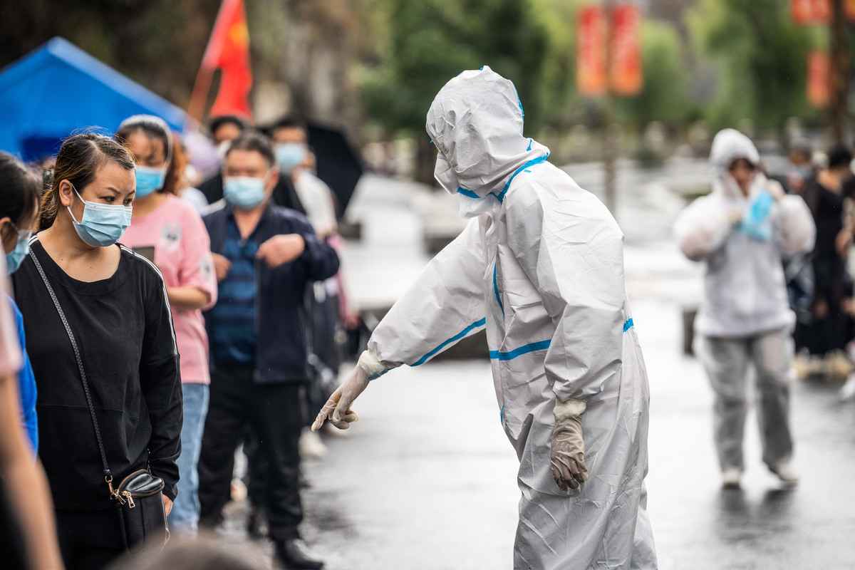 2022年9月16日，貴州畢節居民排隊接受核酸檢測，一個身穿防護服的人在旁指指點點。（CFOTO/Future Publishing via Getty Images∆）