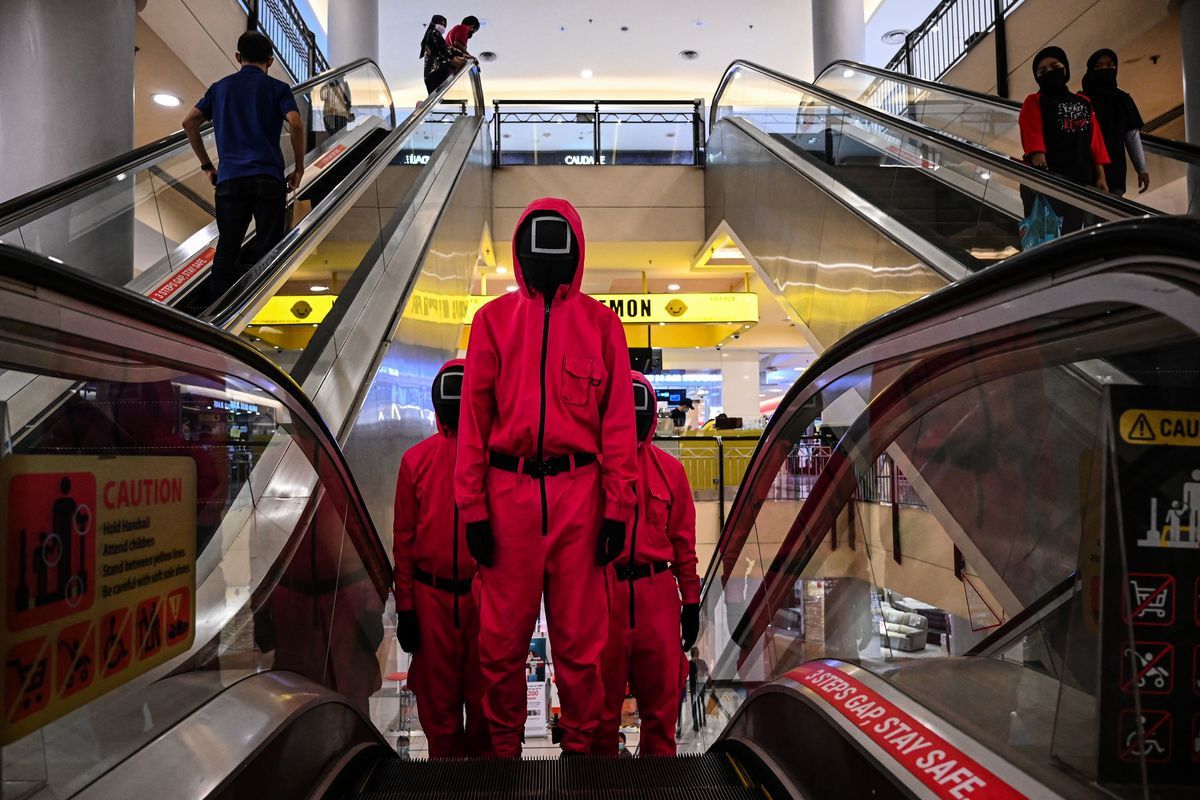 韓劇《魷魚遊戲》，折射出了末世的人類世界。圖為馬來西亞吉隆坡一個購物中心內裝扮成《魷魚遊戲》人物的人們。（MOHD RASFAN/AFP via Getty Images）