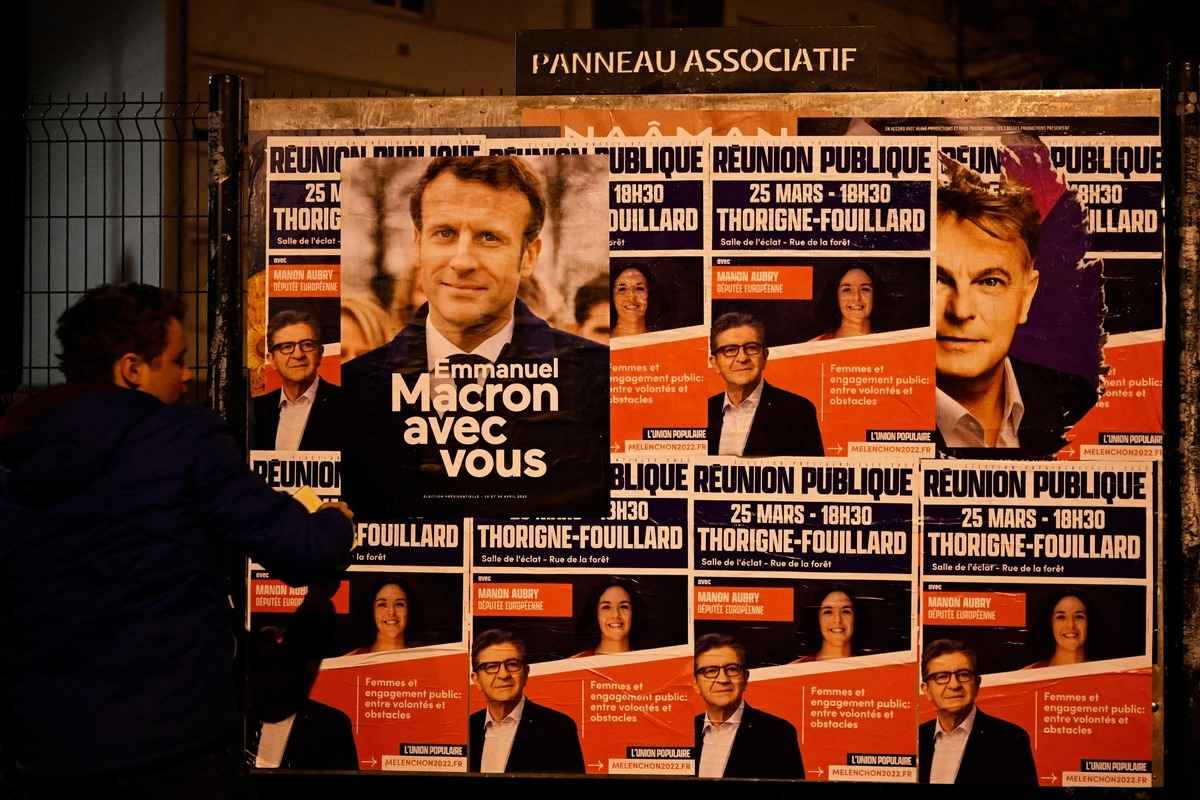 2022年3月24日，在法國西部城市雷恩（Rennes），執政的中間派政黨共和國前進黨（La Republique En Marche，縮寫為LREM）的一名支持者將現任法國總統及LREM黨的總統連任候選人馬克龍（Emmanuel Macron）的競選海報貼在廣告牌上。法國選民將於4月前往投票。（Damien Meyer/AFP via Getty Images）