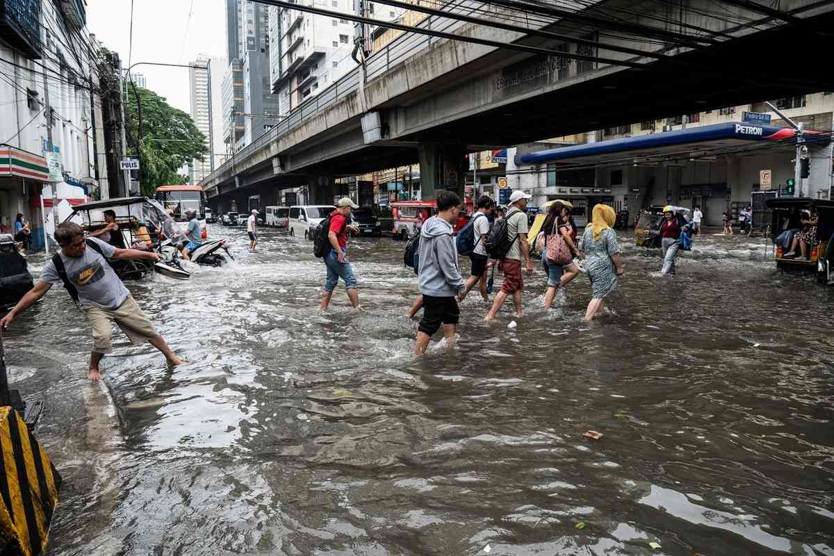 2026年8月10日，菲律賓首都馬尼拉遭暴雨襲擊後，民眾被迫涉水而行。（Ted Aljibe/AFP via Getty Images）