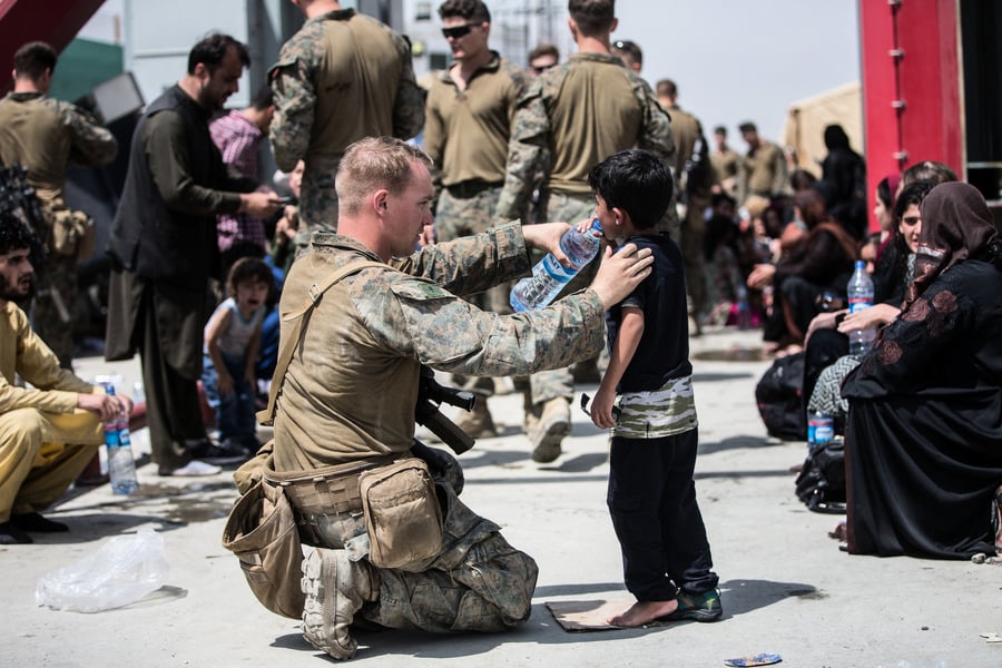 美大兵蹲地給阿富汗兒童餵水 烈日下逗娃超暖心