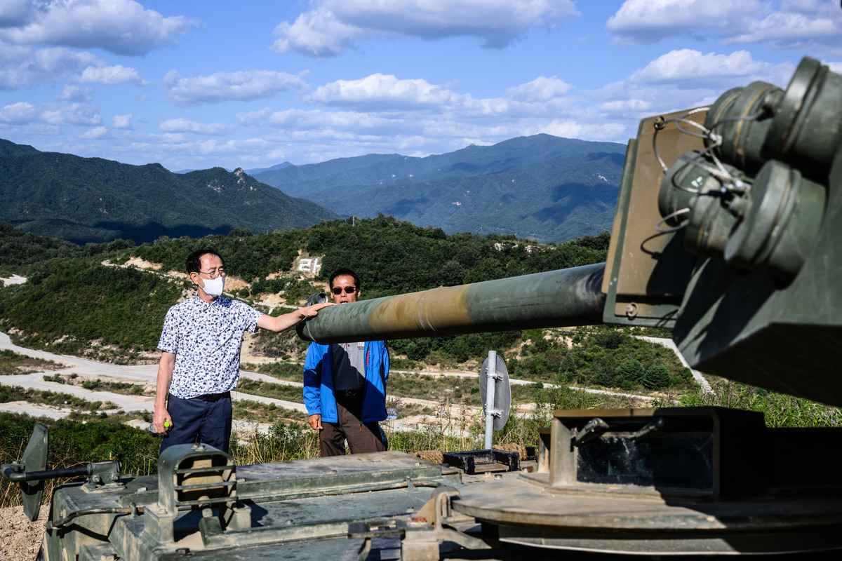 2022年9月20日，南韓抱川市（Pocheon），南韓防務展（DX Korea 2022）前，參觀演習的訪客觸摸了一輛坦克的炮管。（Anthony Wallace/AFP）